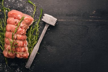 Biberiye ve baharat siyah ahşap zemin ile çiğ et sığır filetosu. Üstten Görünüm. Metin için boş alan