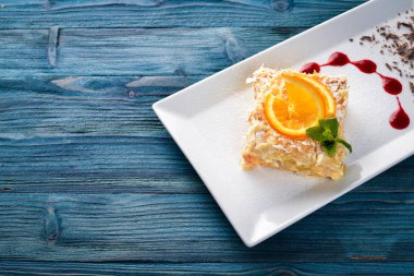 Portakal lezzet ile katmanlı pasta. Ahşap bir arka plan üzerinde. Metniniz için boş alan. Üstten Görünüm.