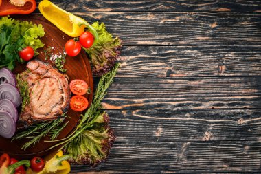 Sebzeli ızgara biftek. Domuz eti, Dana eti, et. Ahşap bir arka plan üzerinde. Üstten Görünüm. Metin için boş alan.
