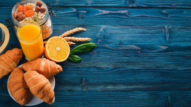 Sağlıklı Diyet kahvaltı. Fındık, yulaf gevreği, meyve, kruvasan, ahşap bir yüzey üzerinde. Üstten Görünüm. Metin için boş alan.