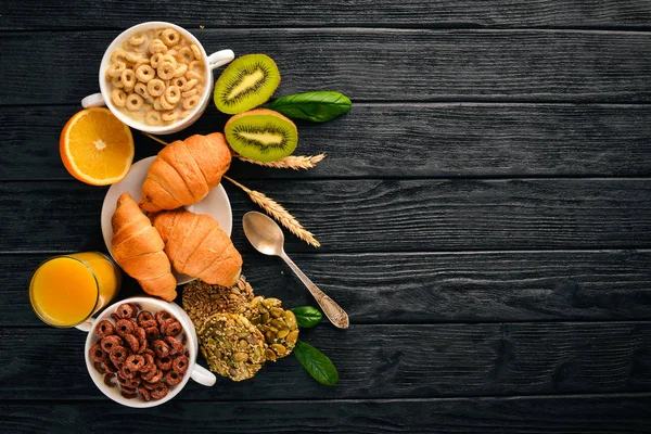 Fitness breakfast, muesli, milk, fruits, nuts and seeds, on a wooden surface. Top view. Free space for text.