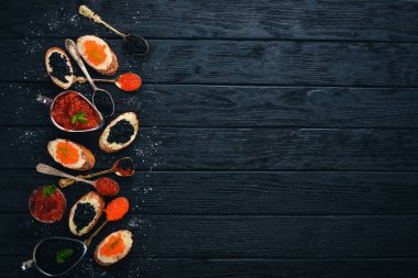 Havyar ile sandviç. Bir kaşık üzerinde havyar. Ahşap bir arka plan üzerinde. Üstten Görünüm. Metin için boş alan.