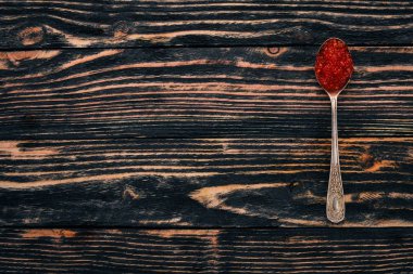 Ahşap arka plan üzerinde kırmızı havyar kaşıkla. Üstten Görünüm. Metin için boş alan.