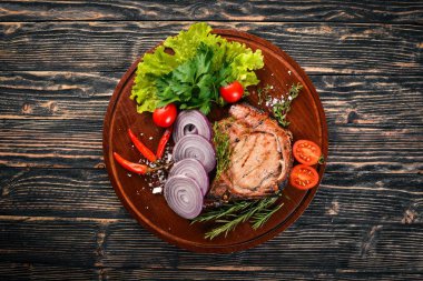 Sebzeli ızgara biftek. Domuz eti, Dana eti, et. Ahşap bir arka plan üzerinde. Üstten Görünüm. Metin için boş alan.
