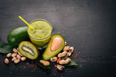 Kivi güler yüzlü ve keten tohumu ve fındık ile avokado. Ahşap bir arka plan üzerinde. Üstten Görünüm. Metniniz için boş alan.