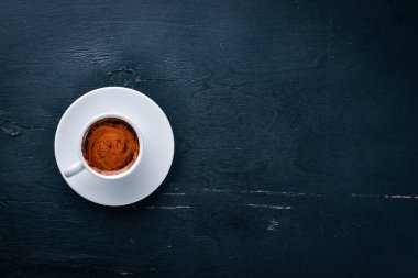 Bir fincan espresso kahve koyu ahşap arka plan üzerinde. Üstten Görünüm. Metin için boş alan.