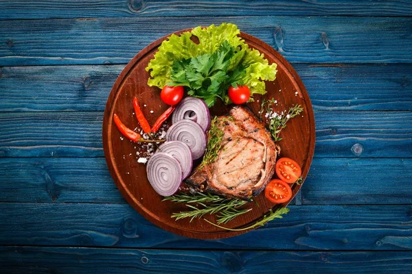 Sebzeli ızgara biftek. Domuz eti, Dana eti, et. Ahşap bir arka plan üzerinde. Üstten Görünüm. Metin için boş alan.