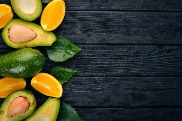 Sinaasappel Avocado Een Houten Achtergrond Bovenaanzicht Vrije Ruimte Voor Tekst — Stockfoto