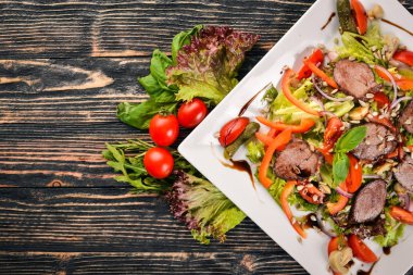 Dana salata, marul ve plaka üzerinde taze sebze. Ahşap bir arka plan üzerinde. Üstten Görünüm. Metin için boş alan.