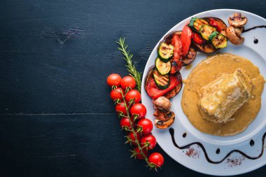 Eti biftek sosu ve ızgara sebzeler. Biftek Voronov. Ahşap bir arka plan üzerinde. Metniniz için boş alan. Üstten Görünüm.