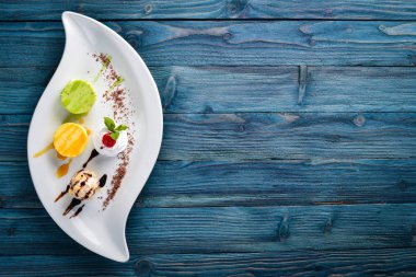 Antep fıstığı, portakal, çikolata tadı ile Panakota. Ahşap bir arka plan üzerinde. Metniniz için boş alan. Üstten Görünüm.