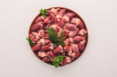 Çiğ tavuk kupa rosemary ile yemek pişirmek için hazır plaka üzerinde ve üzerinde baharat beyaz ahşap arka plan. Üstten Görünüm. Metin için boş alan.