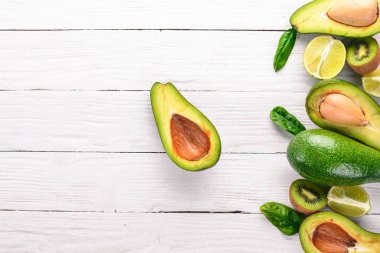 Avokado, kivi ve kireç ahşap arka plan üzerinde. Üstten Görünüm. Metniniz için boş alan.