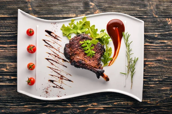 Domates ve bir fındık ile bir kemik biftek. Biftek Fiorentino. Ahşap bir arka plan üzerinde. Metniniz için boş alan. Üstten Görünüm.