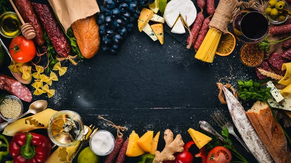 Çeşitli peynir, sosis, şaraplar, geleneksel baharat ve ahşap arka plan üzerinde taze sebze. Peynir brie, mavi peynir, gorgonzola, fuete, salam. İtalyan ve İspanyol mutfağı. Boş alan.