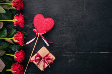 Sevgililer günü afiş. Gül ve bir hediye. Ahşap bir arka plan üzerinde. Üstten Görünüm. Metniniz için boş alan.