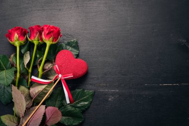 Sevgililer günü afiş. Gül ve bir hediye. Ahşap bir arka plan üzerinde. Üstten Görünüm. Metniniz için boş alan.