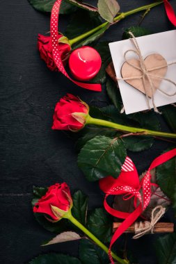 Bir mektup. Bir zarf, bir gül, bir hediye. Ahşap bir arka plan üzerinde. Üstten Görünüm. Metniniz için boş alan.