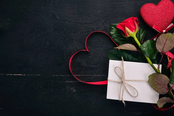 给心爱的人的信 一个信封 一朵玫瑰 一份礼物 在木制背景上 顶部视图 文本的可用空间 — 图库照片