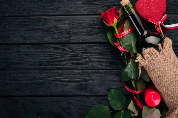 一瓶红酒和一束红玫瑰 情人节在木制背景上 顶部视图 文本的可用空间 — 图库照片
