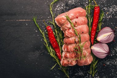 Biberiye ve baharat siyah ahşap zemin ile çiğ et sığır filetosu. Üstten Görünüm. Metin için boş alan