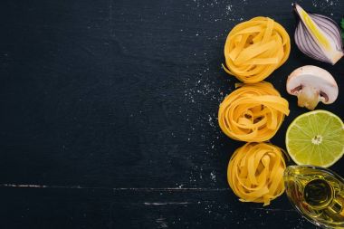 Makarna tagliatelle, ahşap bir zemin üzerine sebzeli fettuccine kuru. Geleneksel İtalyan mutfağı. Üstten Görünüm. Kopya alanı.