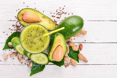 Avokado ve salatalık keten tohumu ve fındık ile güler yüzlü. Ahşap bir arka plan üzerinde. Üstten Görünüm. Metniniz için boş alan.