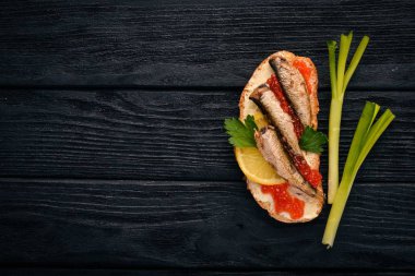 Hamsi ve havyar, soğan, ahşap zemin ile sandviç. Üstten Görünüm. Kopya alanı.