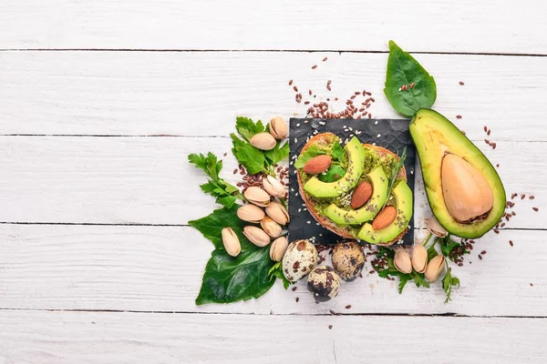 Sandwich Met Avocado Amandelen Een Houten Achtergrond Bovenaanzicht Vrije Ruimte — Stockfoto