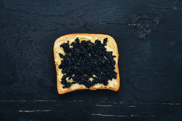 Sandwich Met Zwarte Kaviaar Boter Een Houten Achtergrond Bovenaanzicht Vrije — Stockfoto