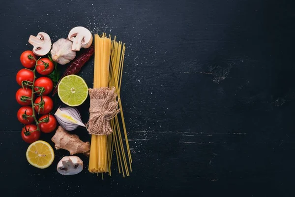 新鮮な野菜とスパイスのスパゲッティ イタリアの伝統的な料理 木製の背景 平面図です コピー スペース — ストック写真
