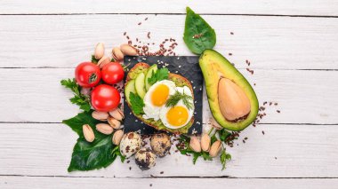 Bıldırcın yumurta, salatalık ve antep fıstığı ile avokado sandviç. Ahşap bir arka plan üzerinde. Üstten Görünüm. Metniniz için boş alan.