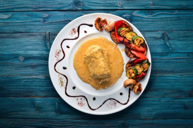 Eti biftek sosu ve ızgara sebzeler. Biftek Voronov. Ahşap bir arka plan üzerinde. Metniniz için boş alan. Üstten Görünüm.