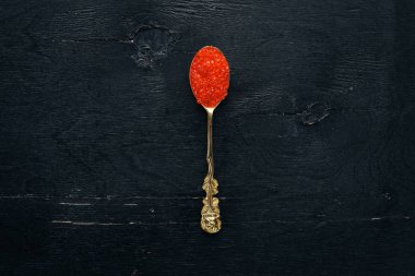 Ahşap arka plan üzerinde kırmızı havyar kaşıkla. Üstten Görünüm. Metin için boş alan.
