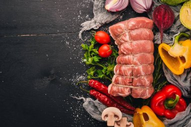 Taze sebze ve biberiye ve baharat siyah ahşap zemin ile çiğ et sığır filetosu. Üstten Görünüm. Metin için boş alan.