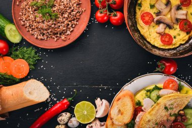 Kahvaltı. Omlet, karabuğday, mantar, fındık, taze sebze. Ahşap bir arka plan üzerinde. Üstten Görünüm. Kopya alanı.