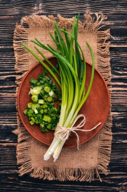Ahşap arka plan üzerinde taze yeşil soğan. Üstten Görünüm. Metniniz için boş alan.