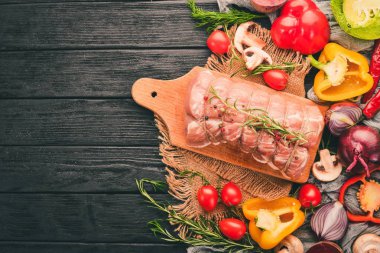 Taze sebze ve biberiye ve baharat siyah ahşap zemin ile çiğ et sığır filetosu. Üstten Görünüm. Metin için boş alan.