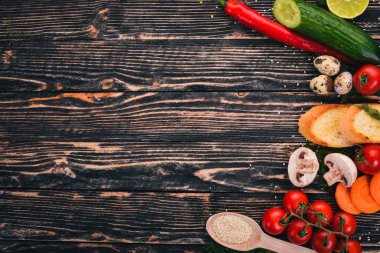 Yemek pişirmek için hazırlık. Kiraz domates, baget, Bıldırcın yumurta, salatalık, mantar. Ahşap bir arka plan üzerinde. Üstten Görünüm. Kopya alanı.