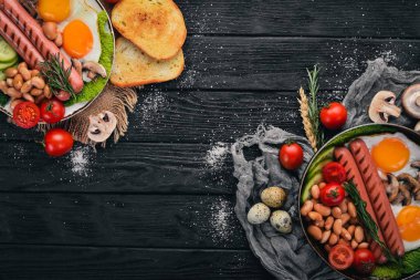 Tam İngiliz kahvaltısı kızarmış yumurta, sosis, fasulye, tost ve kahve kopya alan arka plan üzerinde. Siyah bir ahşap arka plan üzerinde.