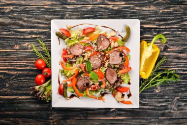 Dana salata, marul ve plaka üzerinde taze sebze. Ahşap bir arka plan üzerinde. Üstten Görünüm. Metin için boş alan.