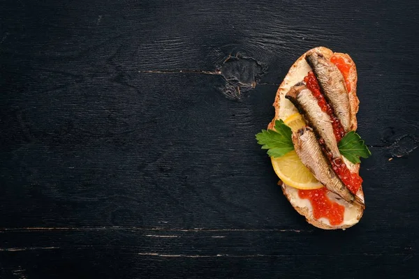 Sandwich Con Espadines Caviar Cebolla Sobre Fondo Madera Vista Superior — Foto de Stock