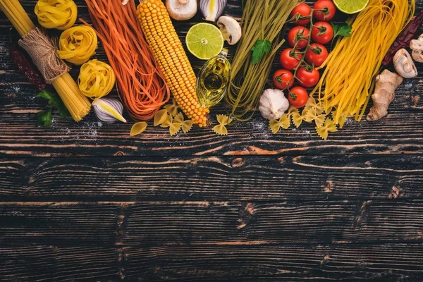 イタリア料理 新鮮な野菜やスパイス パスタ ラーメン スパゲティのセットです 暗い木製の背景 平面図です コピー スペース — ストック写真