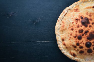 Pizza volkan. Gorgonzola peyniri, domates, taze sebze ve baharat. Ahşap bir arka plan üzerinde. Metniniz için boş alan. Üstten Görünüm.