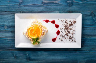 Portakal lezzet ile katmanlı pasta. Ahşap bir arka plan üzerinde. Metniniz için boş alan. Üstten Görünüm.