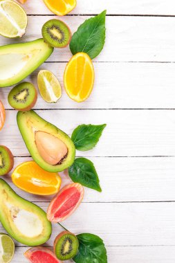 Ahşap arka plan üzerinde meyve. Avokado, limon, portakal, greyfurt ve kivi. Üstten Görünüm. Metniniz için boş alan.