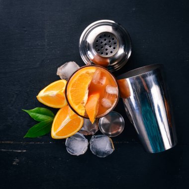 Kokteyl Negroni. Portakal ve viski. Ahşap siyah bir arka plan üzerinde. Üstten Görünüm. Kopya alanı.