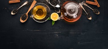 Baharat ve otlar ile cam fincan çay. Siyah ahşap arka plan üzerinde. Üstten Görünüm. Kopya alanı.