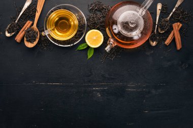 Baharat ve otlar ile cam fincan çay. Siyah ahşap arka plan üzerinde. Üstten Görünüm. Kopya alanı.
