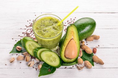 Avokado ve salatalık keten tohumu ve fındık ile güler yüzlü. Ahşap bir arka plan üzerinde. Üstten Görünüm. Metniniz için boş alan.